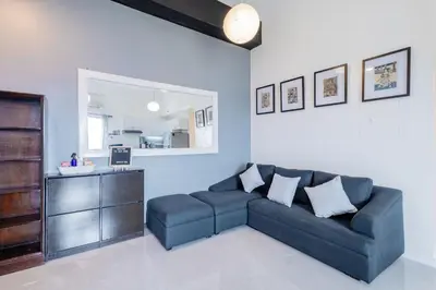 a living room with a blue couch and a mirror at Raya P09 - Airport-Side Penthouse in Manila