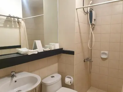 a bathroom with a toilet and a sink and a shower at Raya P09 - Airport-Side Penthouse in Manila