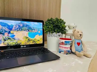 a laptop computer sitting on a table with a teddy bear at Dtravellers Home 2 at SHORE 1 TOWER C (Near MOA) in Manila