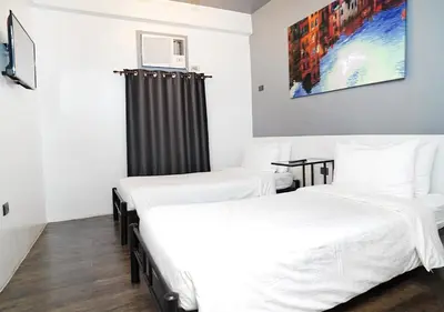 two beds in a room with white sheets at mySTAY Hotel BGC North in Manila