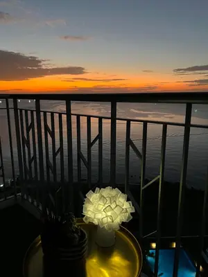 a table with flowers on a balcony with a sunset at 1BRFacing ManilaBay SunsetNear Okada Solaire 1Park in Manila