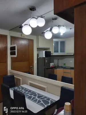 a kitchen with a table and chairs and lights at Rqui CondoTel Near Airport in Manila