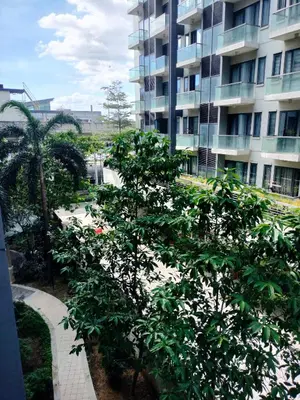 a building with a tree in front of a building at Rqui CondoTel Near Airport in Manila