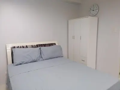 a bedroom with a bed and a clock on the wall at SnugglePod Condotel - Grand Riviera Suites, US Embassy Manila, Roxas Blvd in Manila