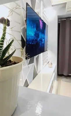 a living room with a tv and a plant on a table at LIGHT HOUSE ( MOA STAYCATION) in Manila