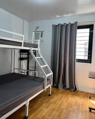 a bedroom with a bunk bed and a window at Sebastians Crib in Dasmariñas