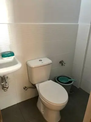 a bathroom with a white toilet and a sink at Sebastians Crib in Dasmariñas