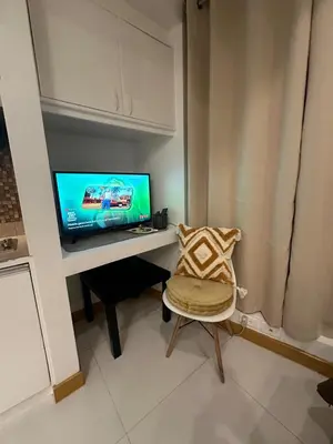 a room with a desk with a tv and a chair at Cozy Place with City View at Greenbelt Makati in Manila