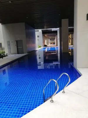 a swimming pool with blue tiles in a building at S ResidencesTower 3 - L&R Staycation in Manila