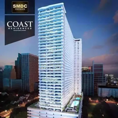a tall white building in a large city at City and Sea view Staycation at Coast Residences in Manila