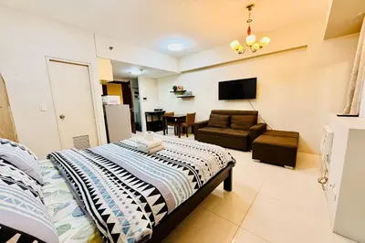 a bedroom with a bed and a living room with a couch at Del's Condotel across NAIA Terminal 3 in Manila
