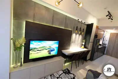 a living room with a television on a wall at DM's Place Family Suite B - Condo in Pasay in Manila