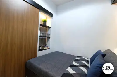 a bedroom with a bed and a wooden cabinet at DM's Place Family Suite B - Condo in Pasay in Manila