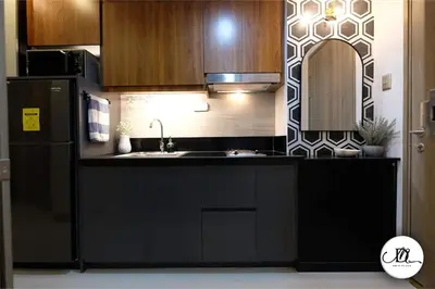 a kitchen with a black refrigerator and a sink at DM's Place Family Suite B - Condo in Pasay in Manila