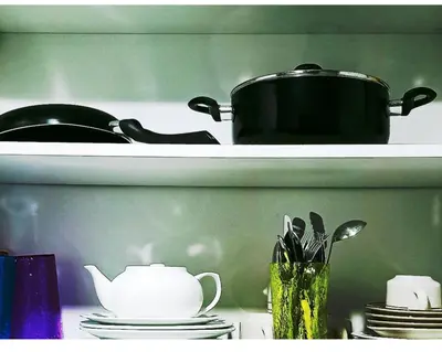 a pot on a shelf with plates and utensils at Marivic's Place at Air Residences Makati in Manila