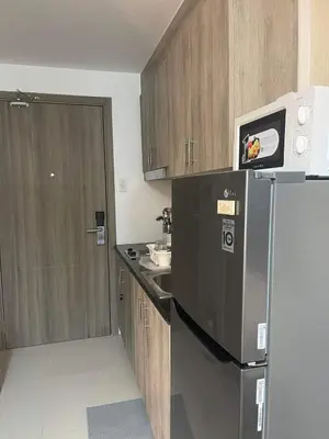 a small kitchen with a refrigerator and a microwave at Staycation Mandaluyong Fame residences greenfield district by darpm in Manila