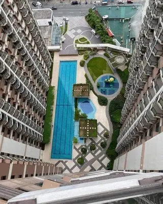 an aerial view of a building with two swimming pools at Best Value Q Condo Radiance29S near Airport, Casinos, Star City, MOA, PICC, Harbour Square, Dolomite Beach in Manila