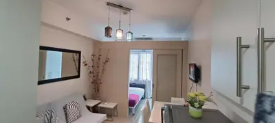 a living room with a couch and a table at Amigo's Place at Sea Residences in Manila