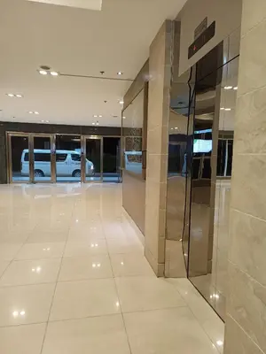 a lobby with a glass elevator in a building at Amigo's Place at Sea Residences in Manila