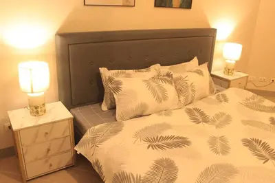 a bedroom with a bed and two lamps on tables at A2J Luxury 3BR Suite Near Uptown Mall BGC Taguig in Manila