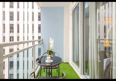 a small table on a balcony with a window at The Bahama Hammock - Azure PH in Manila