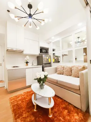a living room with a white couch and a table at The Bahama Hammock - Azure PH in Manila