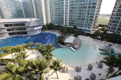 an aerial view of a large swimming pool in a resort at The Bahama Hammock - Azure PH in Manila