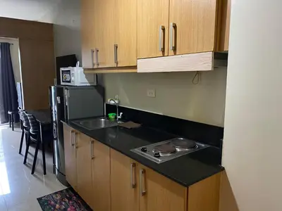 a kitchen with wooden cabinets and a sink and a refrigerator at SHELL RESIDENCE c11 SHORWALK MALL OF ASIA & AIRPORT in Manila