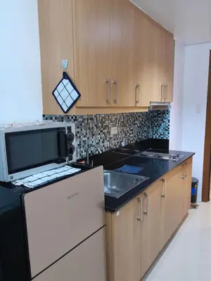 a kitchen with a sink and a microwave at SHELL RESIDENCE C10 SHORWALK TO MALL OF ASIA NEAR AIRPORT in Manila