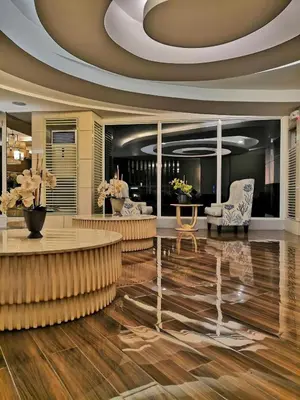 a lobby with a reception desk and chairs in a building at SHORE RESIDENCE D8 NEAR aiRPORT & SHORTWALK TO MALL OF ASIA in Manila