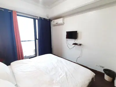 a bedroom with a bed and a phone on the wall at TemporaryHome -susan in Manila