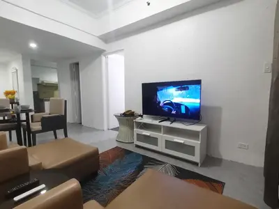 a living room with a flat screen tv on a white wall at Accommodation services in Manila