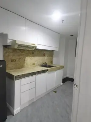 an empty kitchen with white cabinets and a sink at Accommodation services in Manila