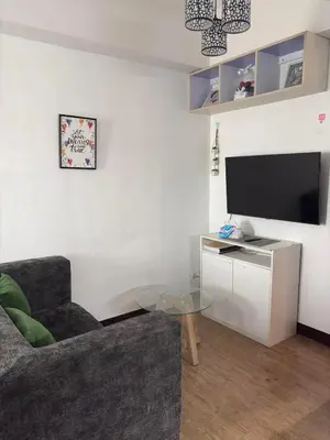 a living room with a couch and a flat screen tv at staycation affordable in Manila