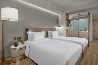 two beds in a hotel room with white pillows at Lanson Place Mall of Asia Manila in Manila