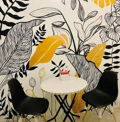 a table with two chairs and a wall with plants at 2 BR staycation beside Enchanted Kingdom in Santa Rosa