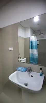 a bathroom with a white sink and a mirror at Shore Residence Tower C2 in Manila