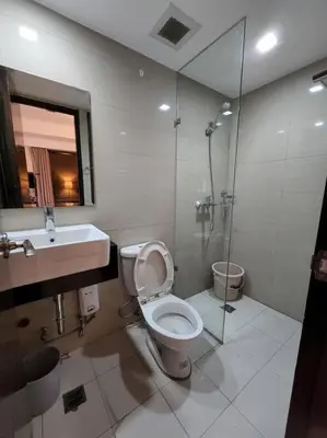 a bathroom with a toilet and a sink and a shower at Casa Antonio at Viceroy McKinley Hill in Manila