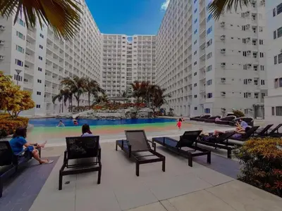 a group of people sitting in chairs in front of a pool at SHORE RESIDENCE D9 Shortwalk Mall of Asia Near Airport in Manila