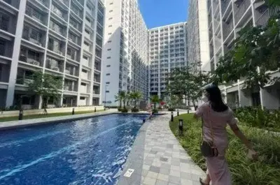 a woman standing next to a swimming pool in a city at SHORE RESIDENCE D9 Shortwalk Mall of Asia Near Airport in Manila