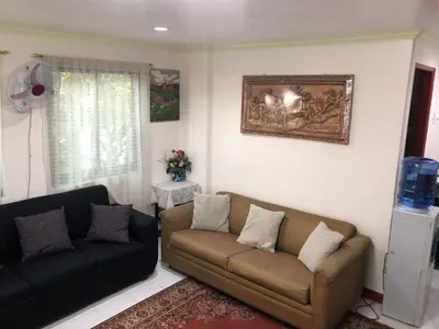 a living room with two couches and a painting on the wall at THE MANSION: FAMILY AND BARKADA BONDING PLACE IN PASAY NEAR AIRPORT in Manila
