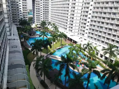an overhead view of a pool with palm trees and buildings at Jam Staycation at Shell Residences in Manila