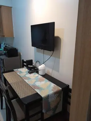 a table with a television on a wall with a table sidx sidx sidx at Jamaica's Place 1br Amenities View at Shell Residences in Manila
