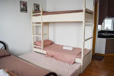 a bedroom with two bunk beds and a sink at The Boni Tower by RSPL Manila City Center in Manila