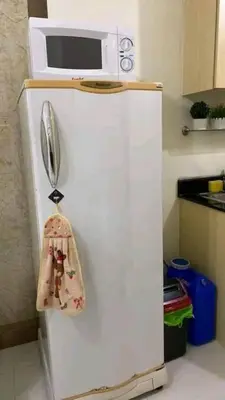 a white refrigerator with a microwave on top of it at CHATEAU ELYSEE a7 near Airport and Sm mall in Manila