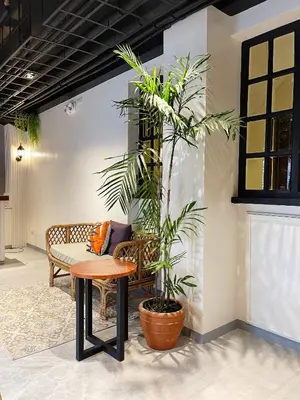 a room with a table and a bench and a plant at Airo Suites Makati in Manila