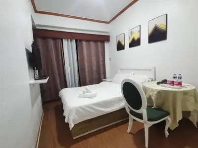 a bedroom with a bed and a table and a chair at Accommodation Service in Manila