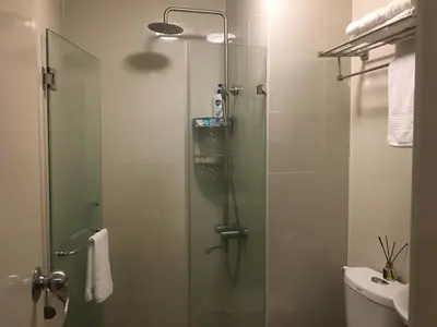 a bathroom with a shower with a glass door at Cozy Condo Near NAIA with WIFI, Pool and Balcony in Manila