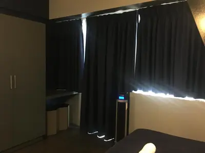 a bedroom with black curtains and a bed and a window at Cozy Condo Near NAIA with WIFI, Pool and Balcony in Manila