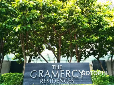 a sign in front of trees in front of a building at The Gramercy Residences in Manila